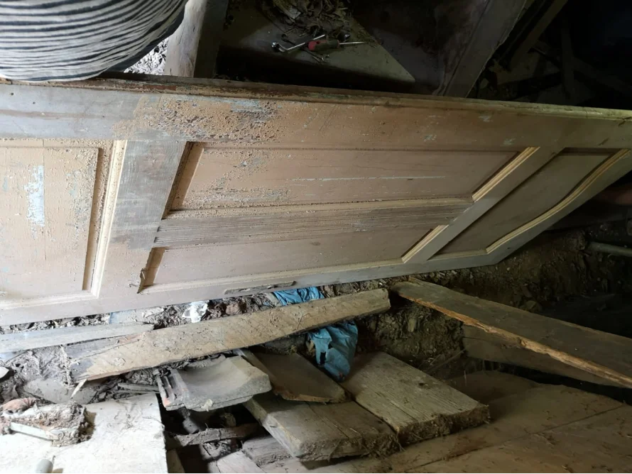 Alte Holztür liegt auf Trümmern