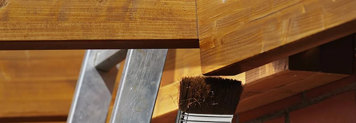 Holzbalken wird mit brauner Farbe gestrichen