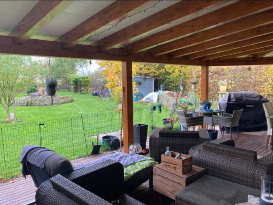 Überdachte Terrasse mit Gartenblick