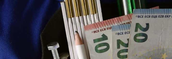 Werkzeug und Euroscheine in Hosentasche