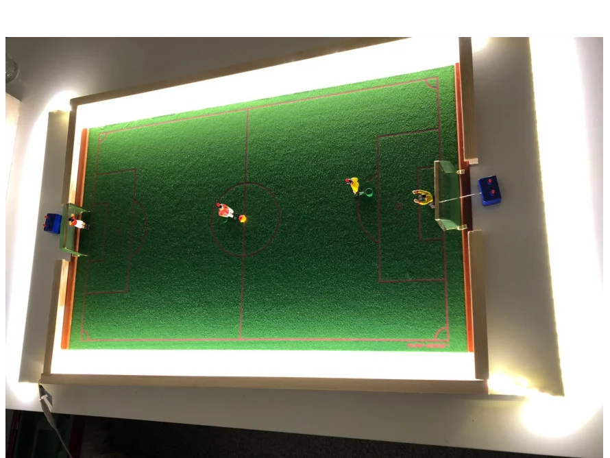 Beleuchteter Tischkicker mit Spielfiguren