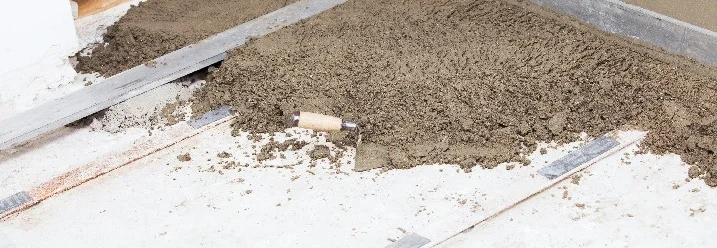 Metallschienen auf Boden, um den Mörtel eben abzuziehen.