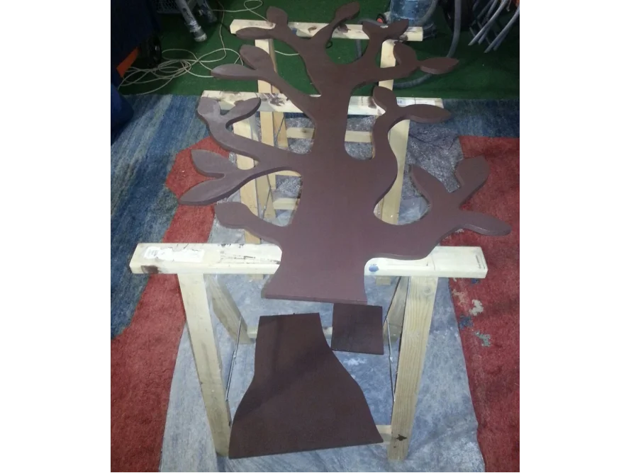 Braune Holzsilhouette eines Baumes auf zwei Holzböcken