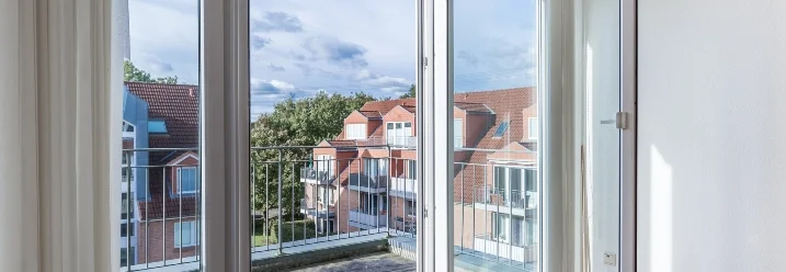 Offene Balkontür mit Blick auf Häuser