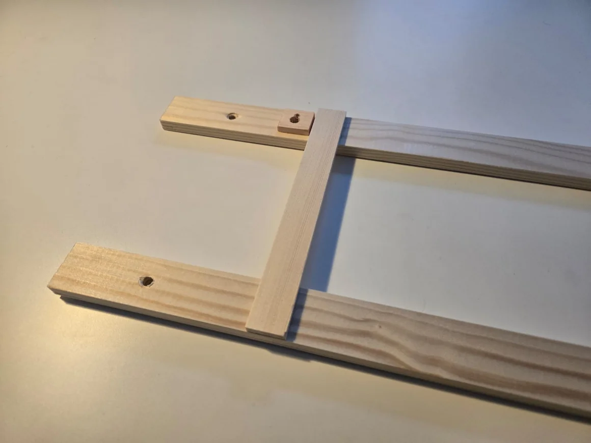 Detail einer unfertigen Bilderleiste mit Aufhängung.