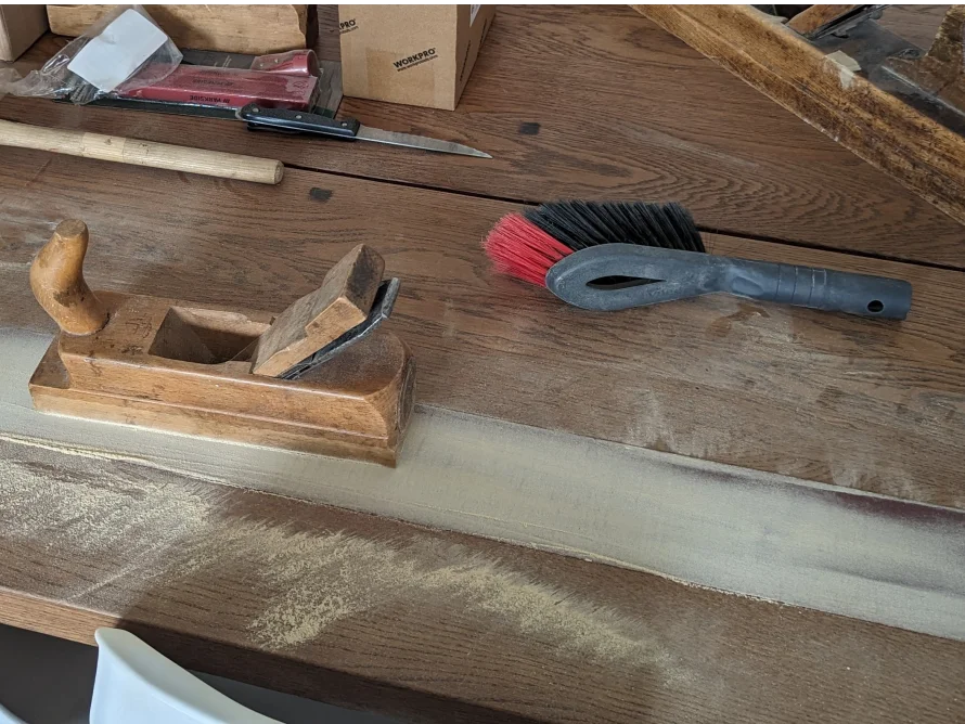 Hobel und Bürste auf Holztisch mit Sägespäne