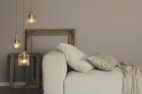 Drei Glaslampen über Sofa