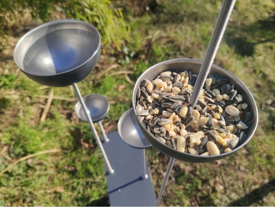 Metallener Vogelfutterspender mit Sonnenblumenkernen und Erdnüssen