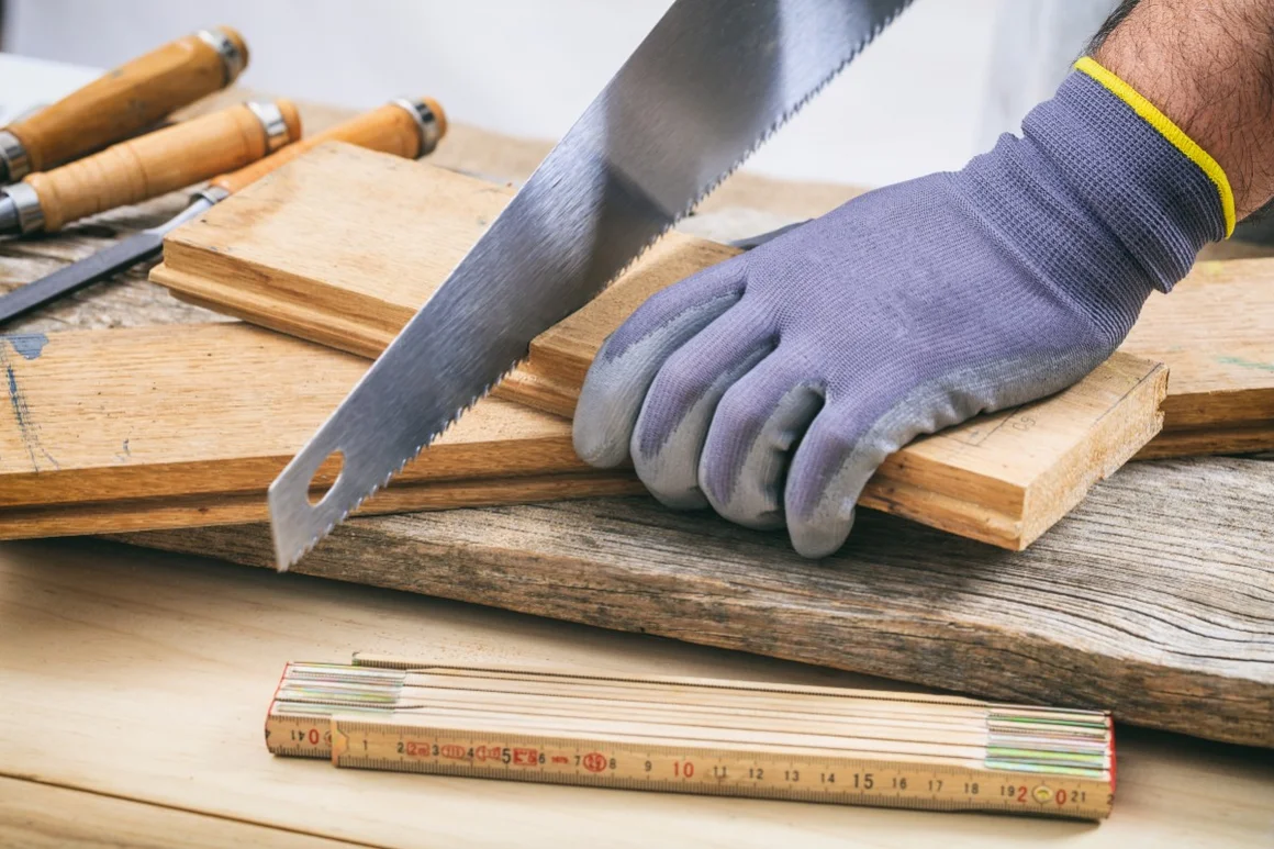Person sägt Holz mit Handsäge