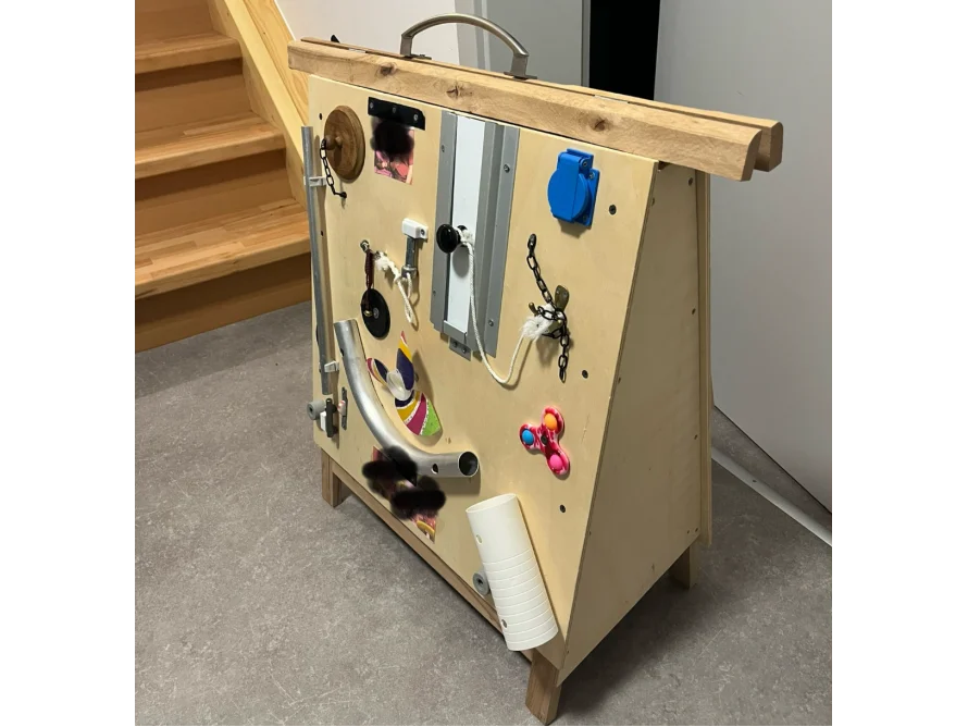 Ein Motorikspielzeug aus Holz mit verschiedenen Elementen.
