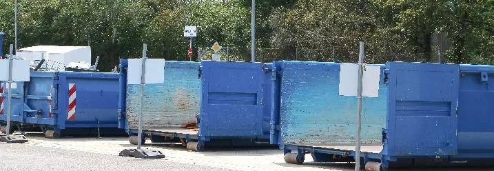Blaue Müllcontainer auf einem Parkplatz