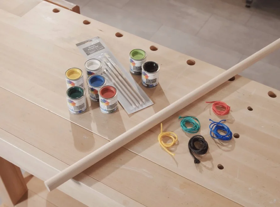 Bastelmaterial: Holzstab, Farbe, Pinsel, Schnur