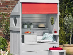 Hölzerne Gartenlounge in Grau mit rotem Sonnenschutz