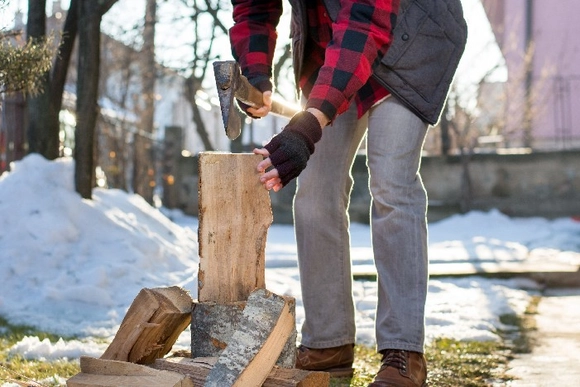 Person hackt Holz mit Axt