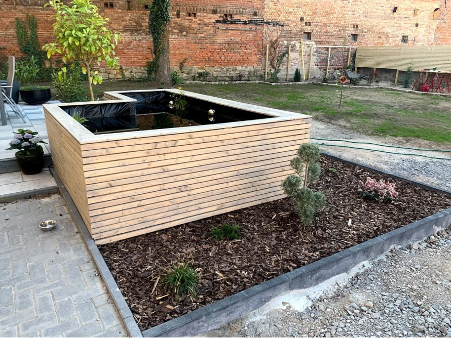 Neu angelegter Gartenteich mit Holzumrandung
