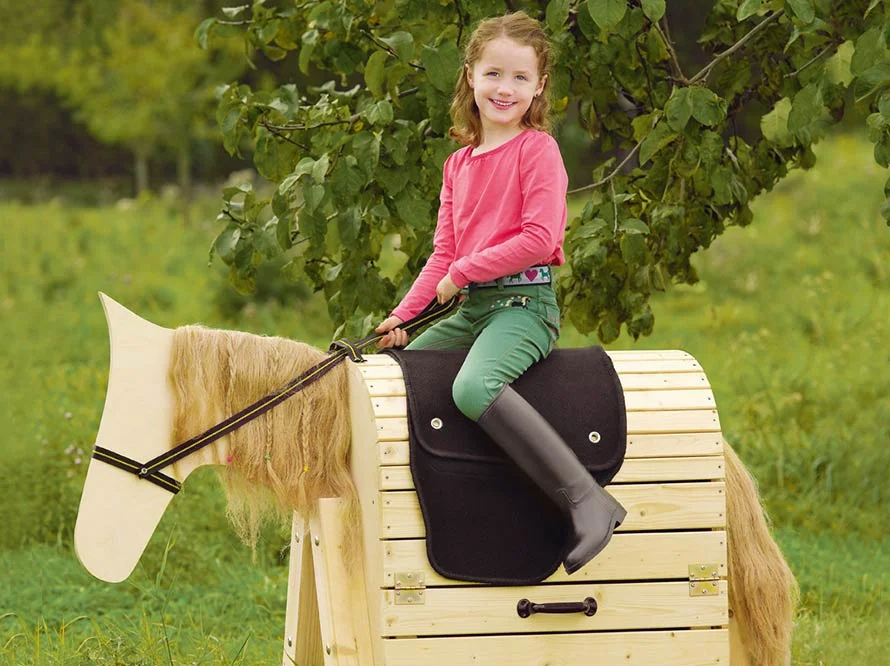 Kind auf einem Spielzeugpferd aus Holz
