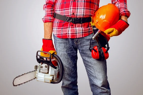 Person mit Kettensäge und Schutzkleidung