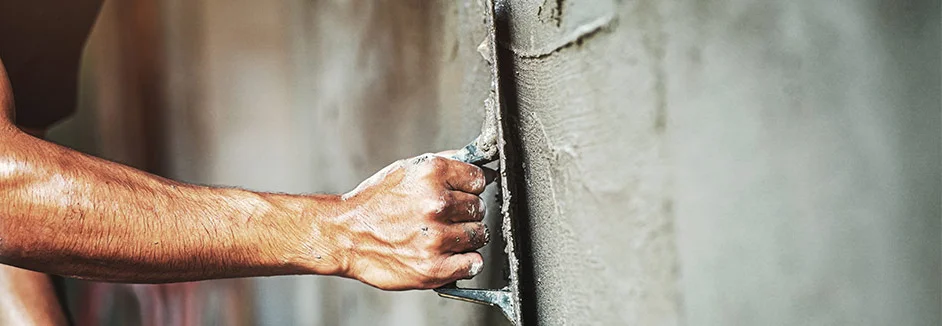 Person verputzt Wand mit Kelle