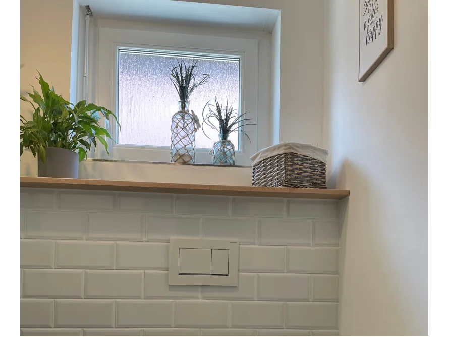 Fensterbank mit Dekoration über weißen Fliesen