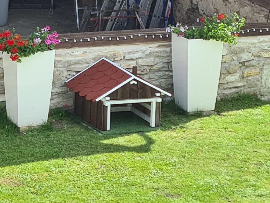 Eine Garage für einen Mähroboter im Design eines Gartenhauses