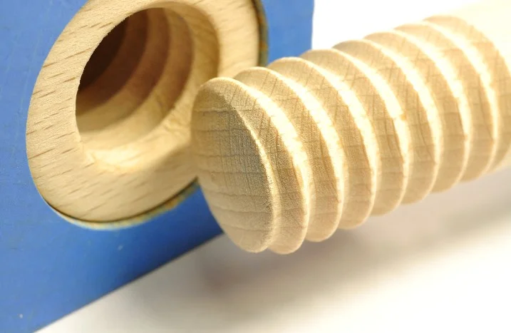 Holzschraube liegt vor einem Holzgewinde