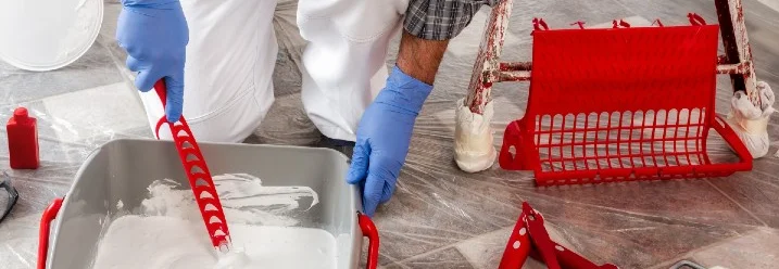 Person rührt Farbe in einem Farbeimer an