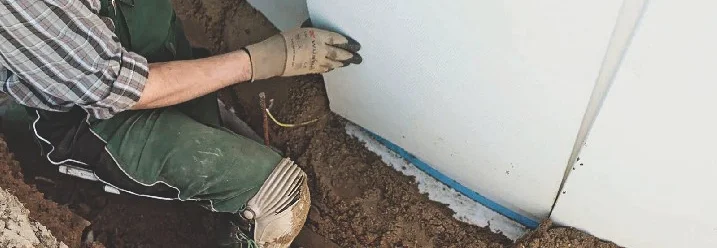 Person beim Anbringen von Dämmung an Stahlwandpool