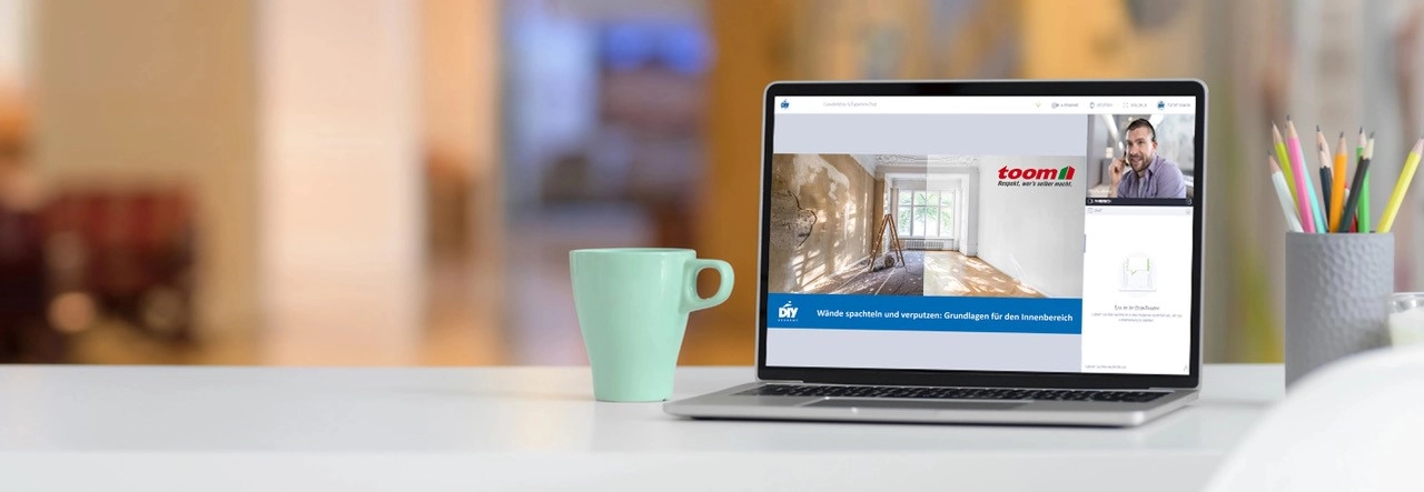 Auf einem Tisch steht ein Laptop, auf dem ein Onlinekurs stattfindet. 