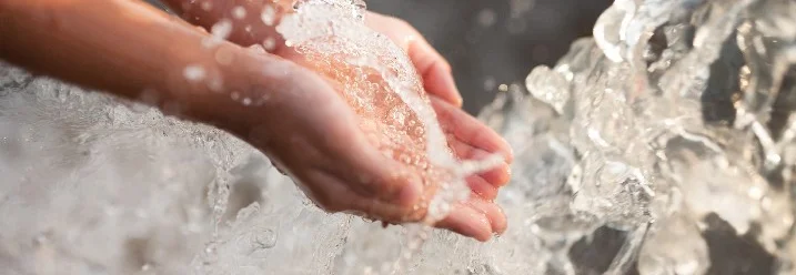 Hände fangen sprudelndes Wasser