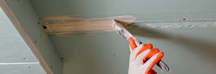 Hand verspachtelt Fuge an Decke