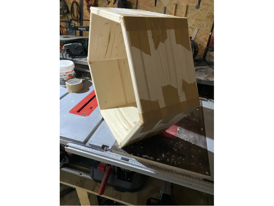 Sechseckiger Holzkasten mit Klebeband auf Tischsäge