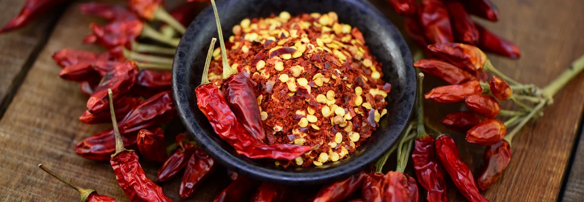 Chiliflocken in einer Schale und getrocknete Chilischoten