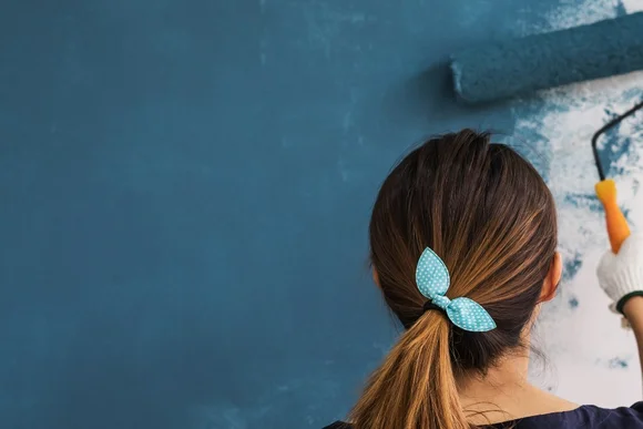 Person streicht Wand blau