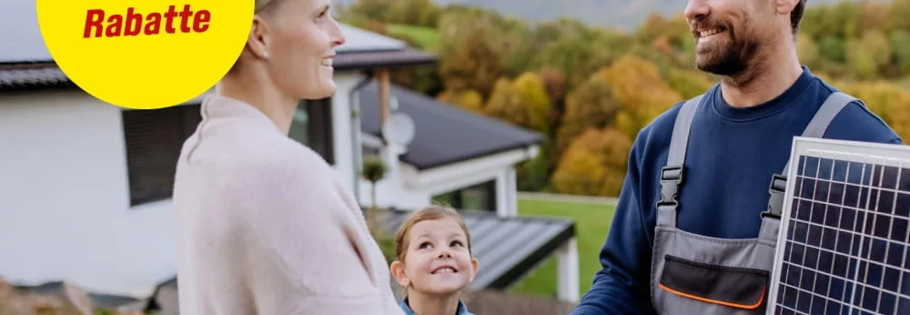Ein Mensch in Arbeitskleidung schüttelt einer Person die Hand und hält ein Solarpanel.