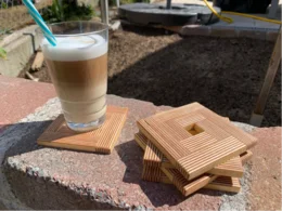 Ein Latte Macchiato steht auf einem Stapel von Holz-Untersetzern