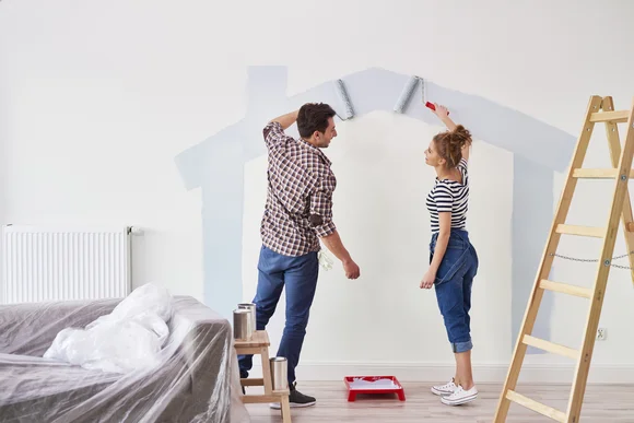 Zwei Personen streichen Wand