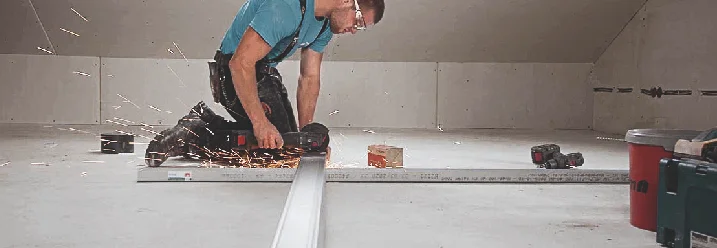 Person baut ein Ständerwerk aus Holz für eine Trennwand.