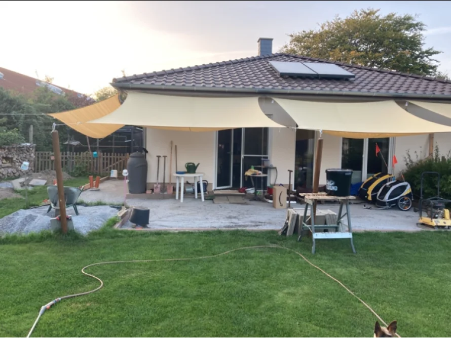 Terrasse mit Sonnensegeln und Gartenwerkzeug