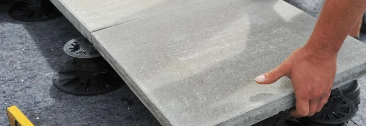 Person verlegt Terrassenplatten