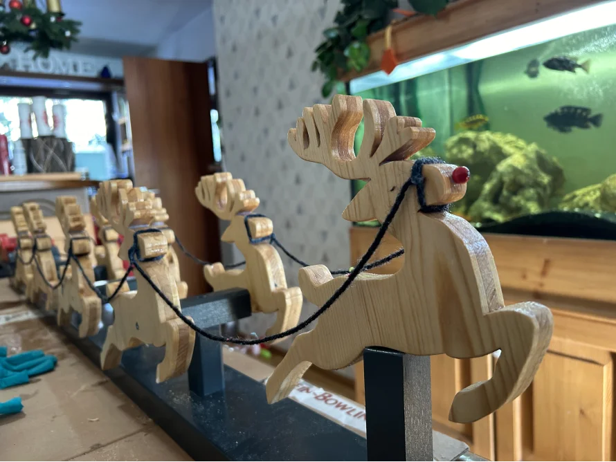 Rentiere aus Holz vor Aquarium