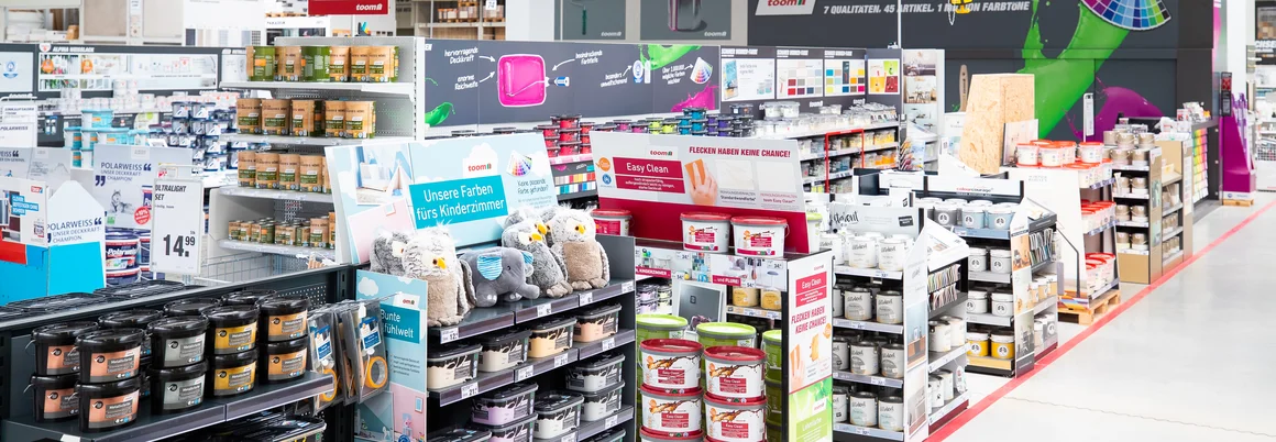 Regalreihen mit Farbeimern und Zubehör in einem Baumarkt