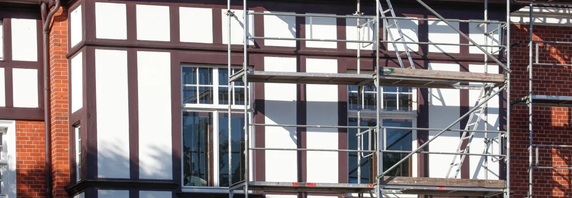 Ein Gerüst steht vor der Fassade eines Fachwerkhauses.