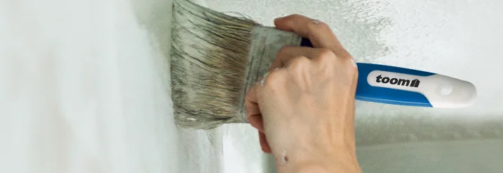 Person streicht Wand weiß
