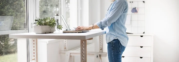 Person arbeitet mit einem Laptop an einem Stehpult