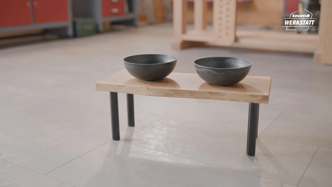 Zwei Futternäpfe auf einem kleinen Holztisch