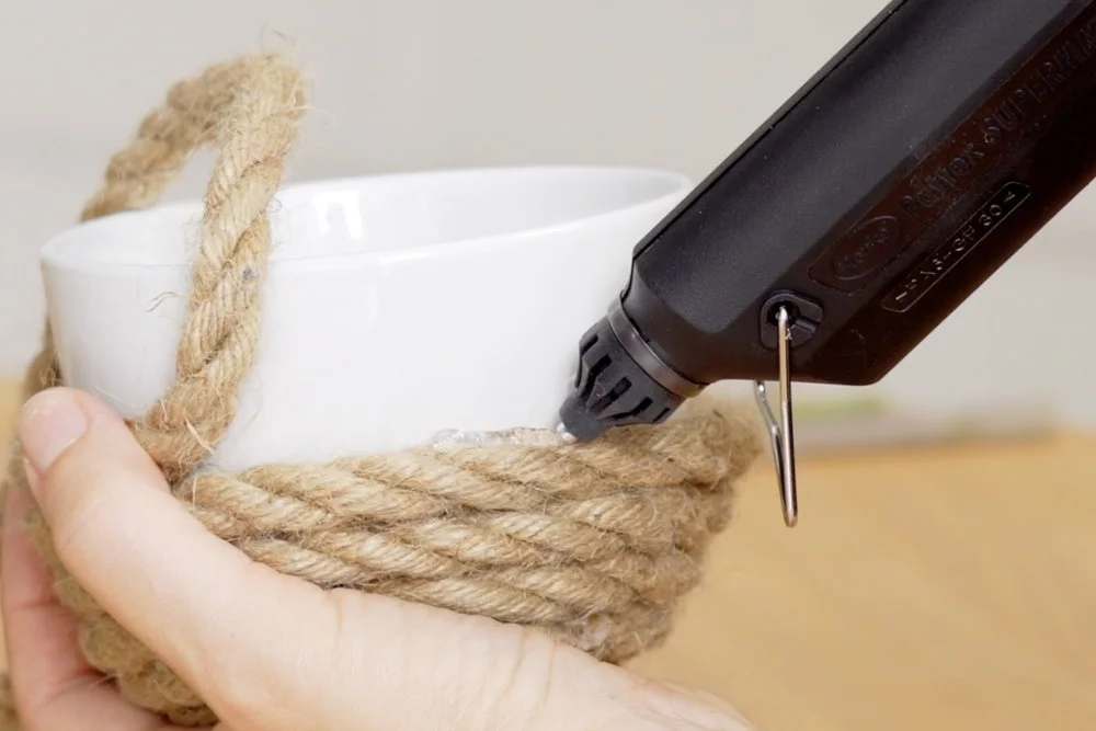 Heißklebepistole verklebt Seil an Tasse