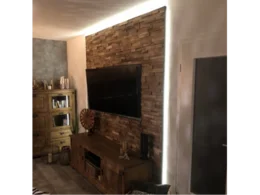 Wohnzimmer mit Holzwand und Fernseher