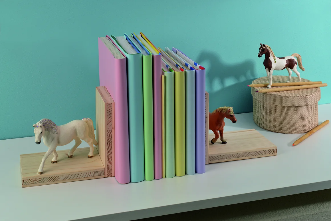 Bunte Bücher zwischen Buchstützen mit Pferden