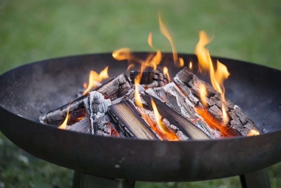Brennende Holzscheite in Feuerschale