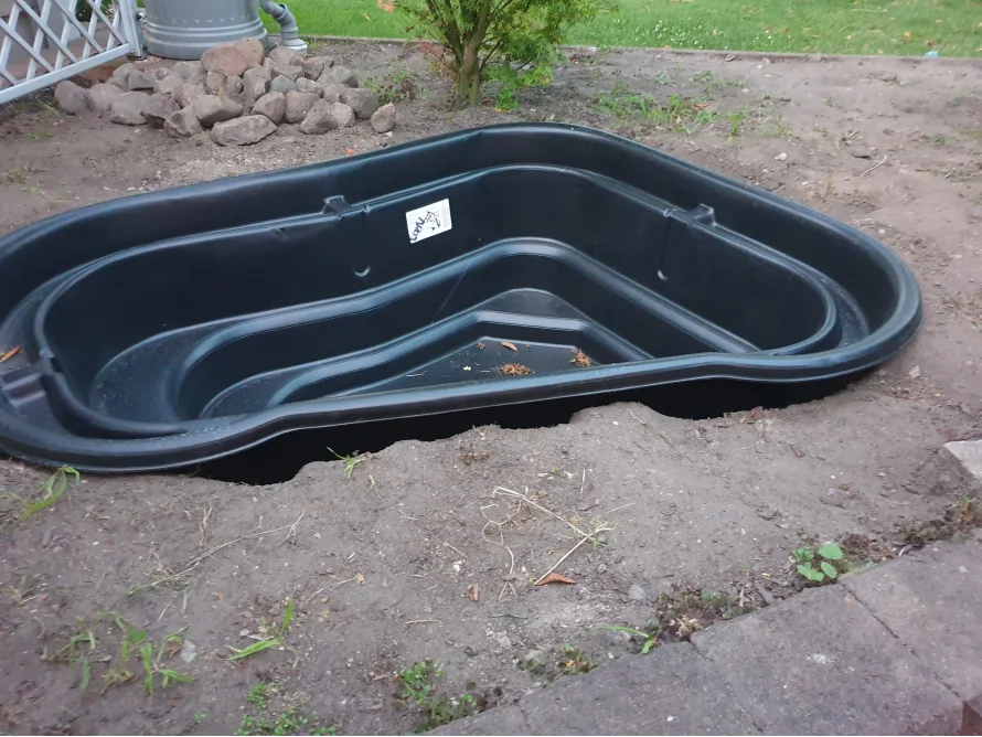 Leere Teichschale aus Plastik im Garten